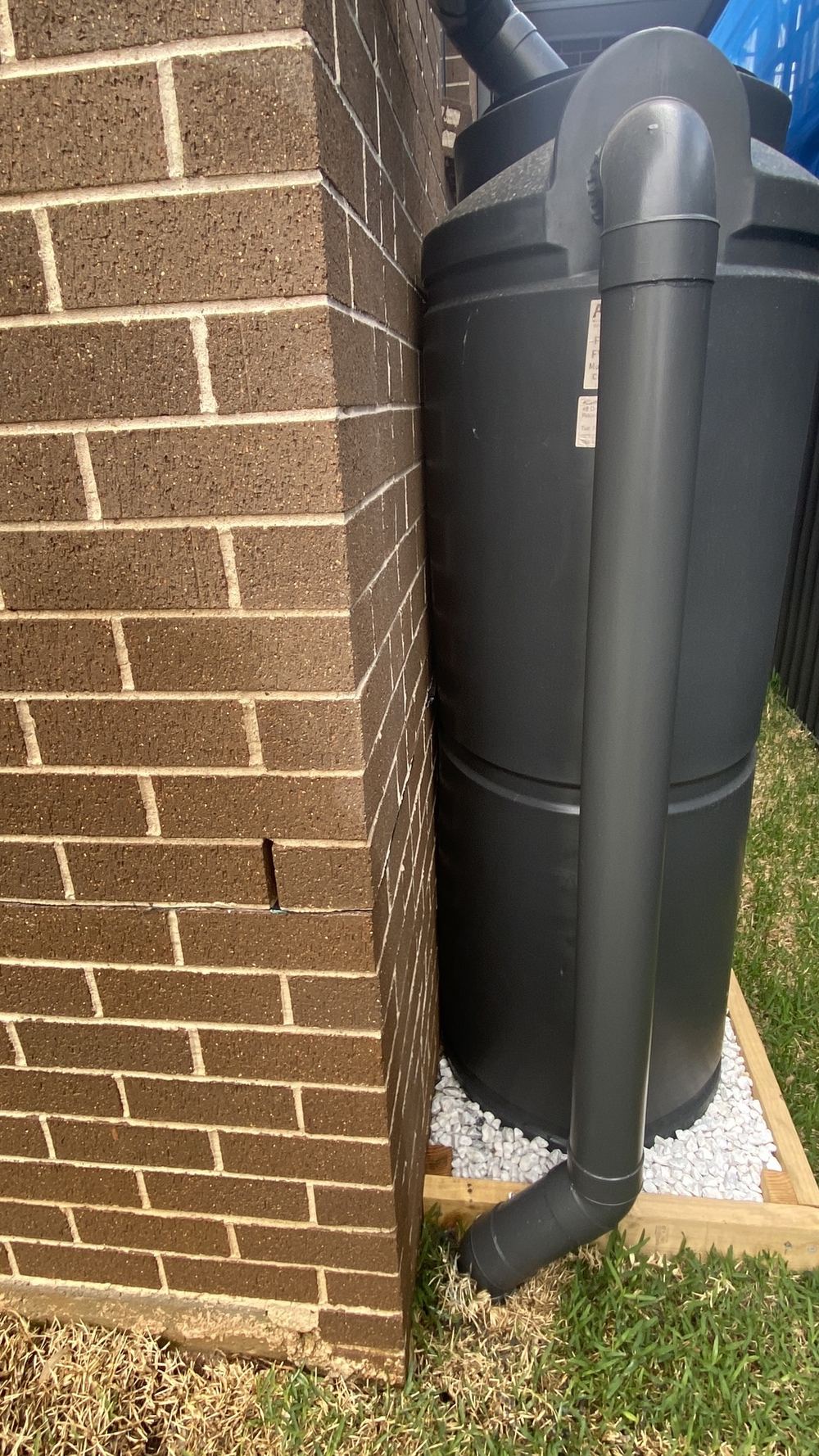 Rainwater tank sitting hard against the brick wall with no clearance, Rouse Hill